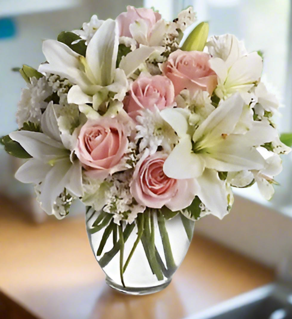 Send lily and roses from flower shop in Winnipeg. Valley Florist offers soft toned vase arrangement for delivery in Winnipeg.