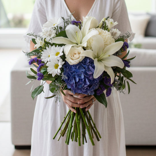 Lily and roses arranged in blue vase by your florist of choice in Winnipeg-Valley flowers